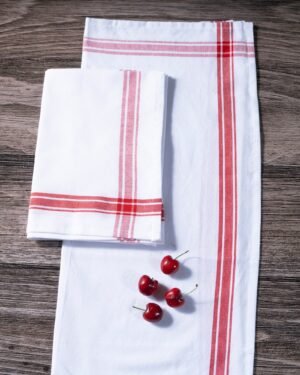 White kitchen towels with red stripes on a wooden surface with cherries.